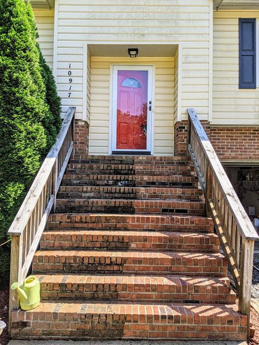 A reviewer's brick steps, one side freshly cleaned, while the other side remains dirty and stained.