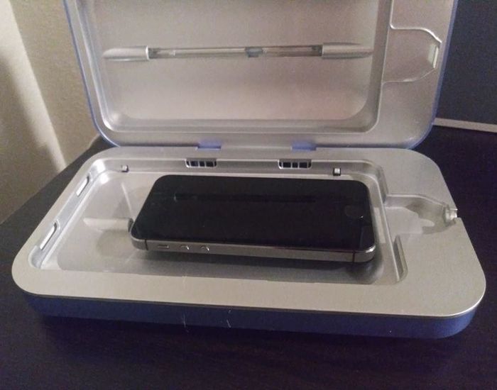 The same reviewer showing the sanitizer open with their phone inside.