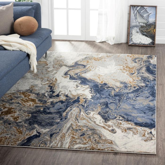 The blue marble-inspired area rug beautifully placed in a modern living room setting.