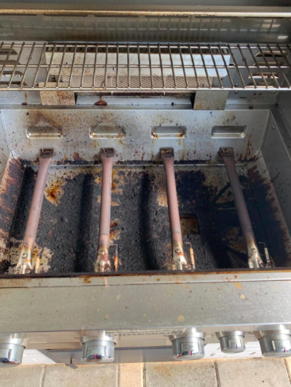A grill covered in stubborn stains and grease before using the grill cleaner