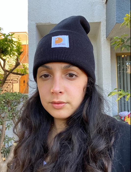 A reviewer wearing a black Carhartt beanie with the signature label