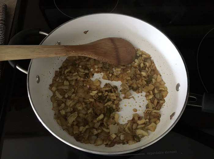 Reviewer showing mushrooms cooking in a pan.