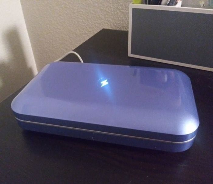 A reviewer demonstrating the closed purple sanitizer.