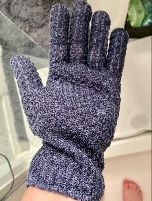 A reviewer wearing a blue fingered glove while in the shower