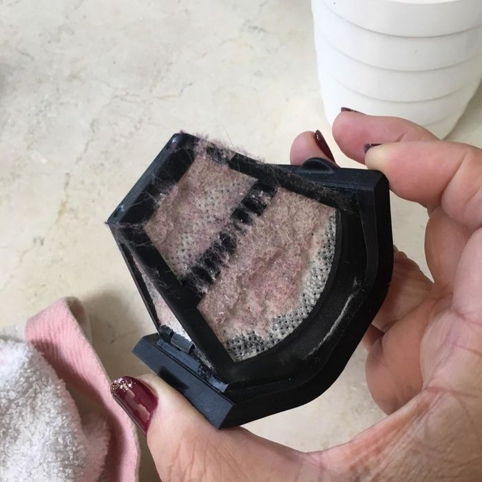 Reviewer holding the filter, now covered in dust