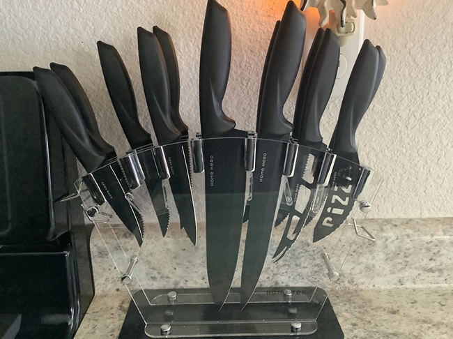 A review image showing black knives stored upside down in a clear display case.
