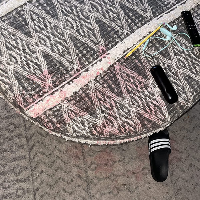 A reviewer’s photo of a pink stain on an area rug