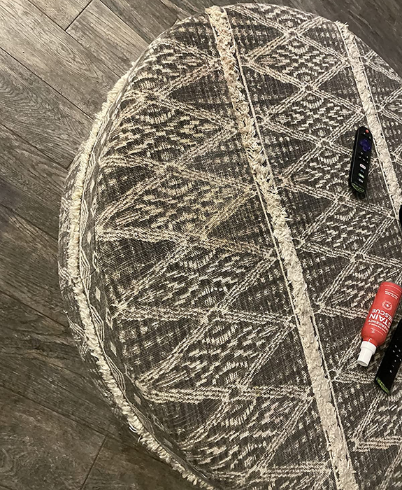 A reviewer’s photo showing the same area rug, now free of the pink stain after using the stain spray