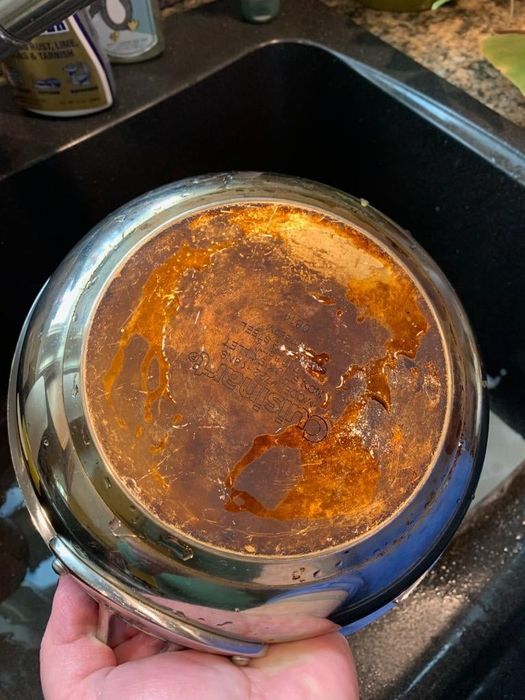 Reviewer’s before photo showing the bottom of a burnt and stained stainless steel pan