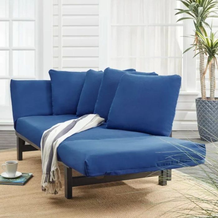 The same blue-cushioned daybed converted into chaise form, placed on a stylishly decorated patio for a laid-back lounging experience.