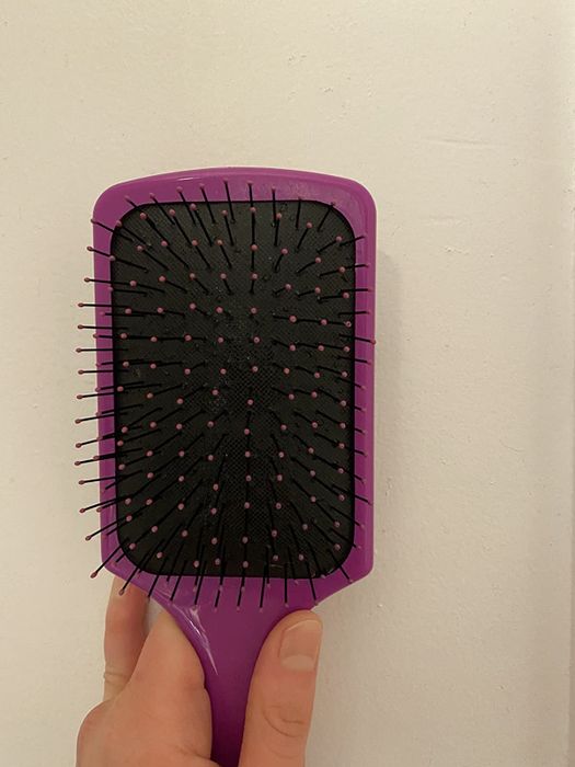 The same hairbrush now spotless, revealing the clean base