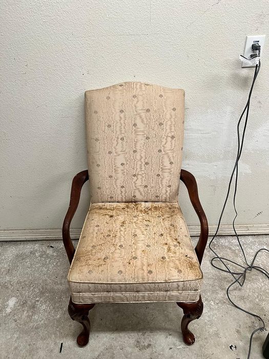 A reviewer's photo showing a chair before being cleaned with the Bissell Little Green, covered in dirt and stains