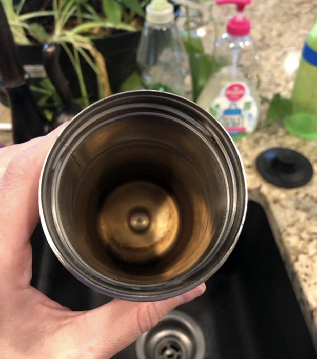 A close-up of a reviewer's water bottle, looking rusty and dirty inside