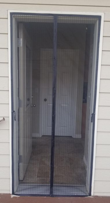 The same mesh curtains now closed across the door frame.