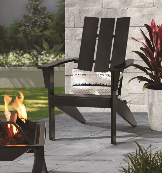 A sleek black Adirondack chair set in a stylishly decorated patio space.
