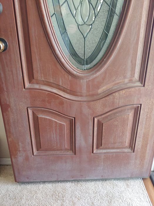 A before picture showing a reviewer's reddish-brown door with a cloudy, dirty appearance