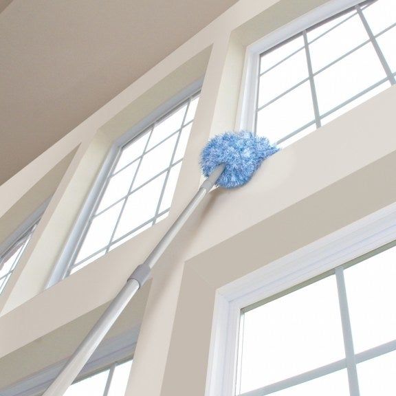 A 360-degree duster on an extension pole cleaning a high windowsill.