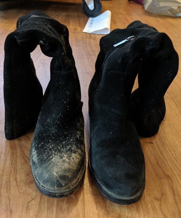 A reviewer displays black suede boots after using the suede and leather brush