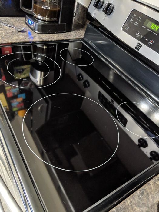 after: the same cooktop, now black and shiny, free of stains