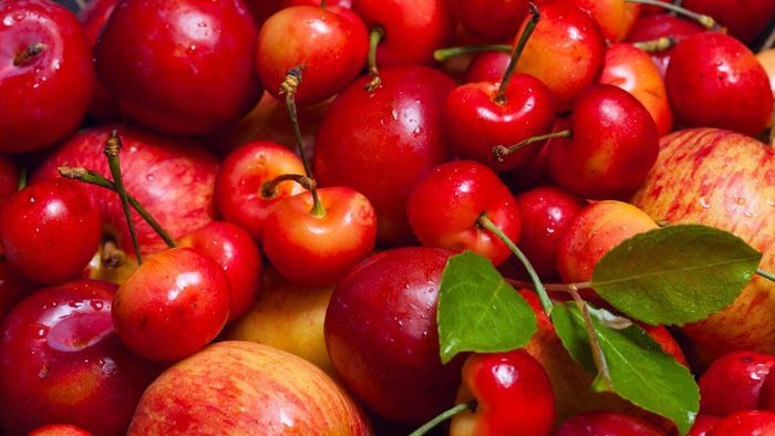A selection of red fruits, such as cherries and apples