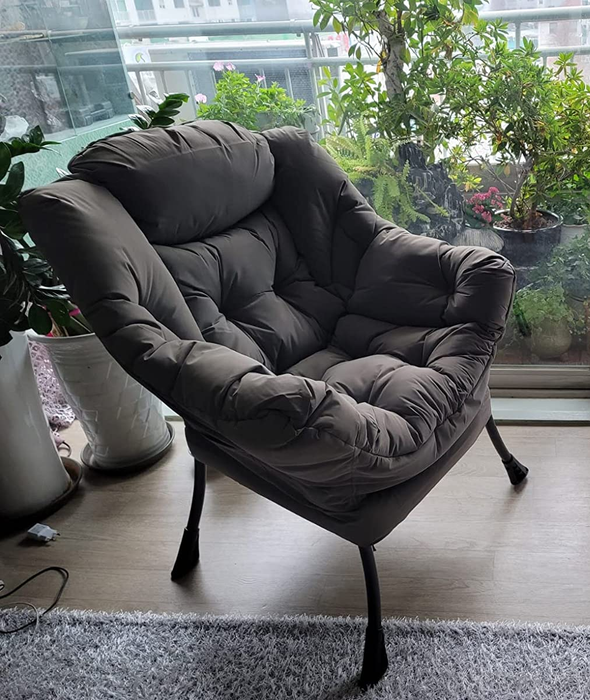 Reviewer image of a side view of a gray chair with four black legs placed on a wooden floor