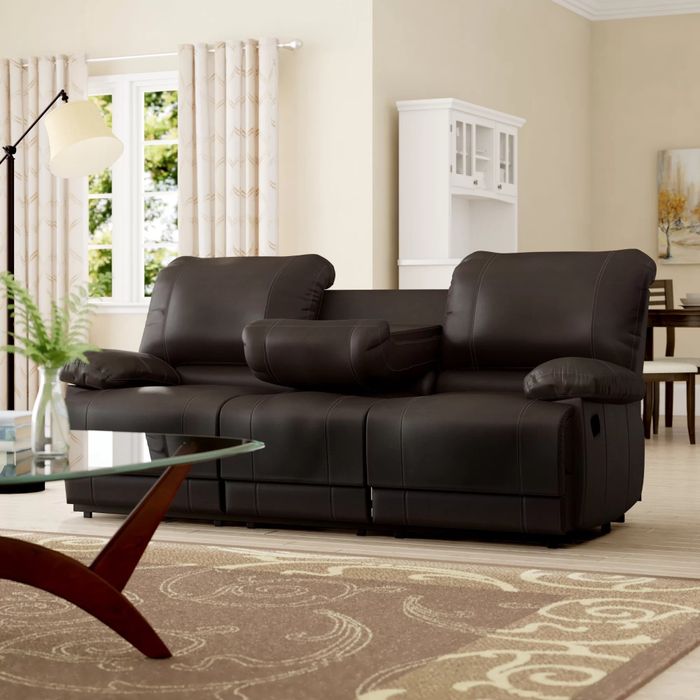 A luxurious black leather sofa in a cozy living room.