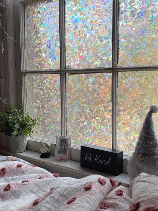 A bedroom window adorned with crystal-like rainbow decorative film.