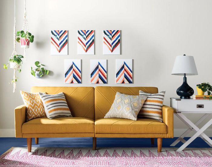 a mustard-colored splitback convertible sofa in a southwestern-inspired living room