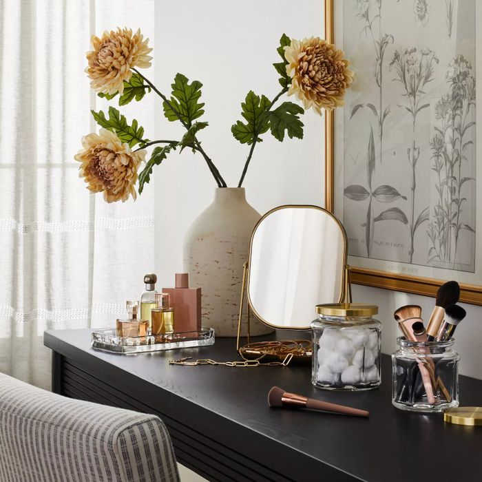 A sleek brass rectangular mirror with a flip design and an attached tray for added functionality.