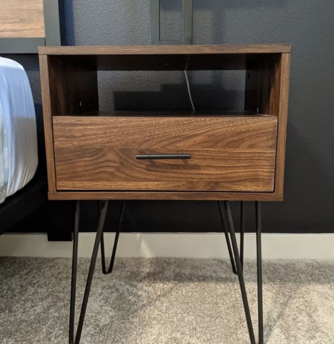 A reviewer's single drawer nightstand in a dark walnut finish with metal hairpin legs