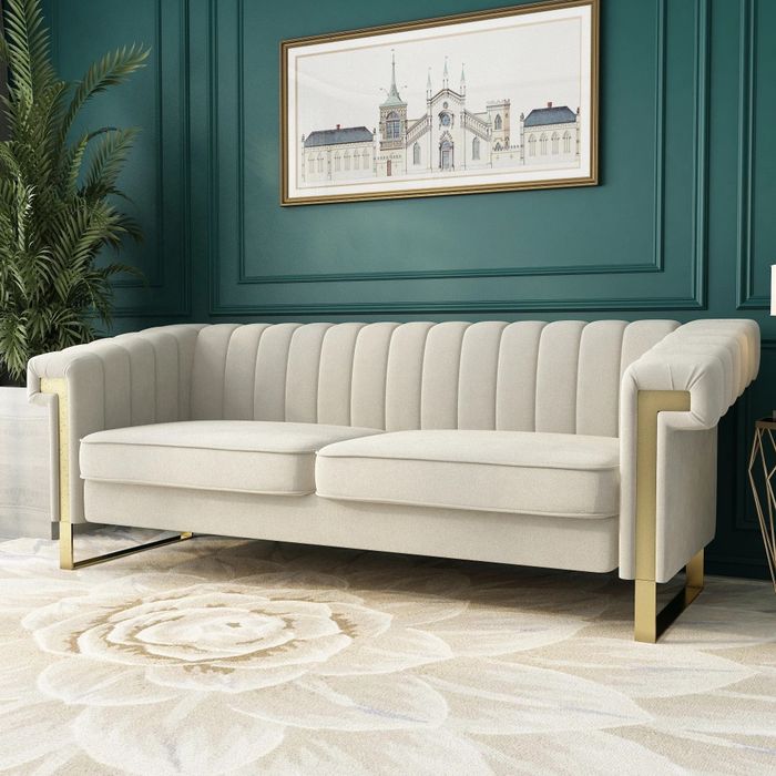 A white and gold sofa placed in a living room featuring a bold green wall.