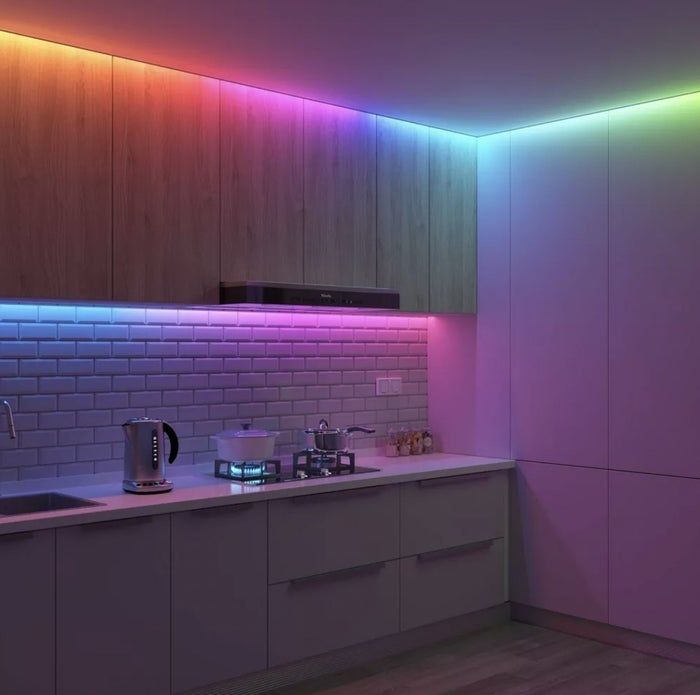 a kitchen illuminated by a vibrant LED light strip