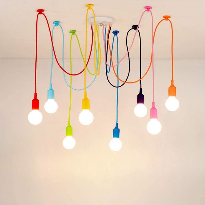 Spider chandelier with vibrant multicolored wires and exposed bulbs creating a playful ambiance.