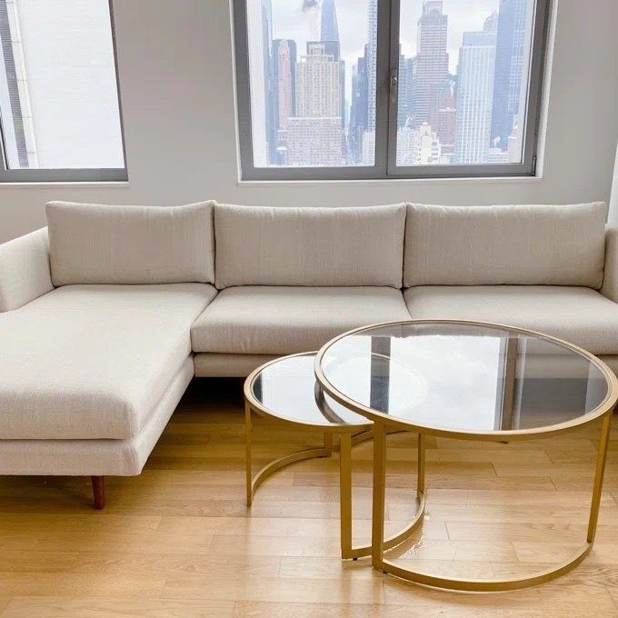 a light cream sectional sofa in a stylish living room with wooden floors