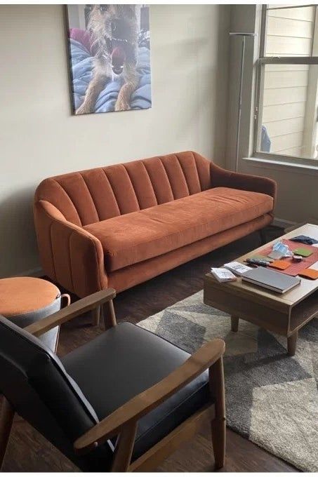 a review photo of the rust-colored sofa