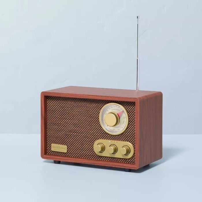 A retro-style radio featuring a wood casing and vintage dials, placed elegantly on a simple surface.