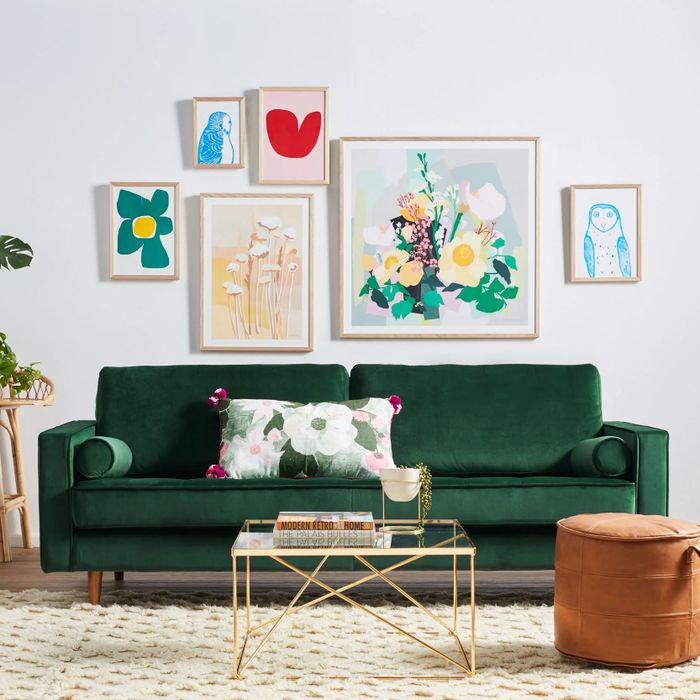 an emerald green velvet sofa in a sleek, contemporary living room
