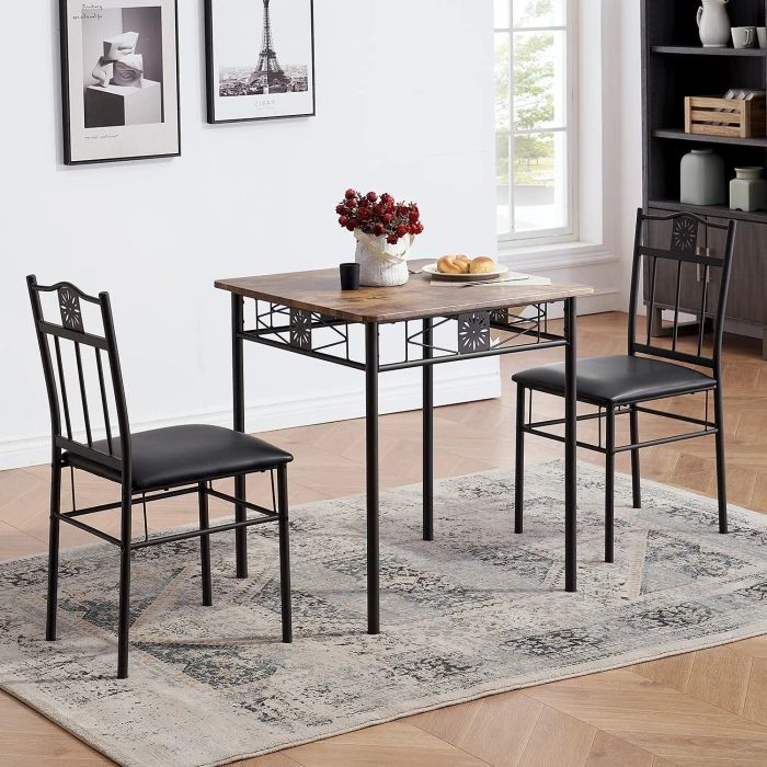 a faux wood-topped table with black metal legs and detailing, with two matching black chairs positioned on either side