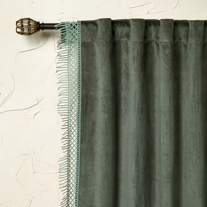 A green curtain adorned with stylish tassel fringe, bringing an elegant touch to the room's decor.