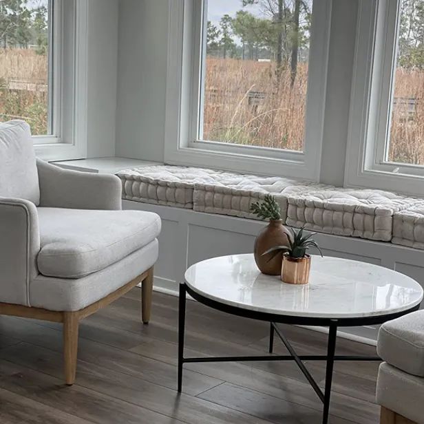 A reviewer’s living room with multiple cushions arranged on the lower wooden shelf.