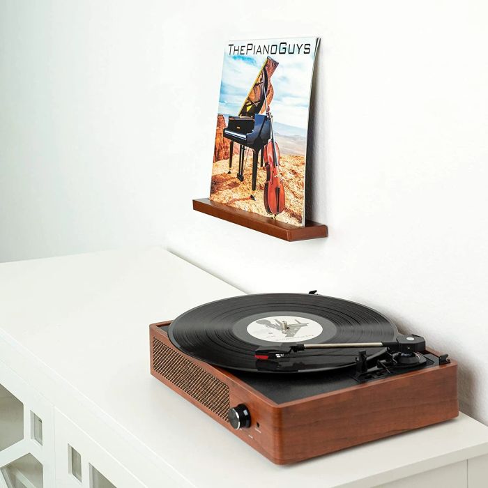 A vinyl record resting on a shelf beside a record player