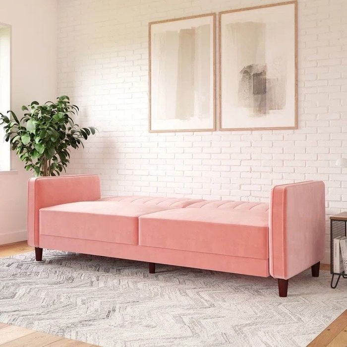 a pink velvet sleeper sofa in a cozy living room setting