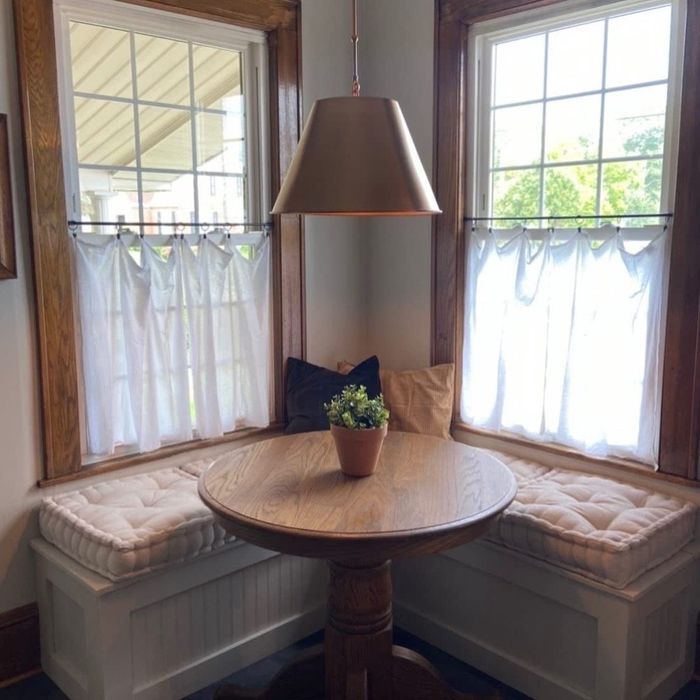 Another reviewer's ivory cushions arranged on a bench around a kitchen dining table
