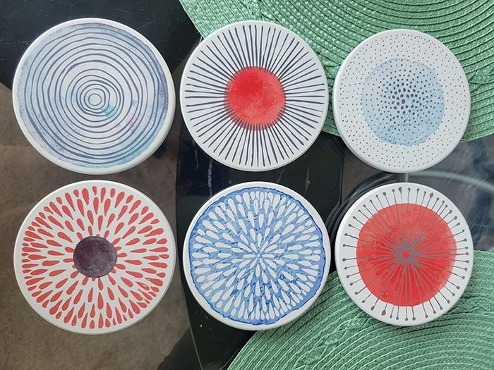 A reviewer's photo showcasing the colorful ceramic coasters in the Colorful Series design.