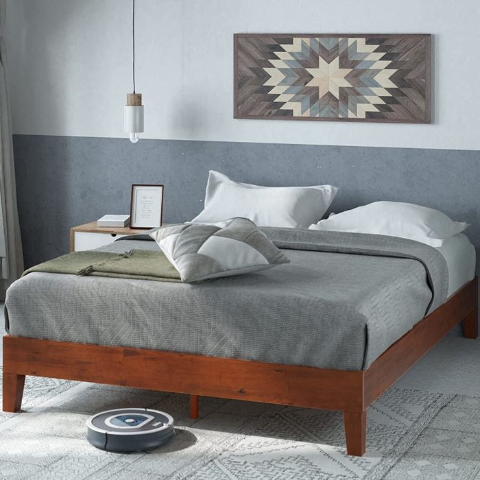 Image of a bed frame with gray linens.