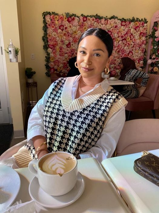 A reviewer wearing the sweater vest in a neutral cream shade