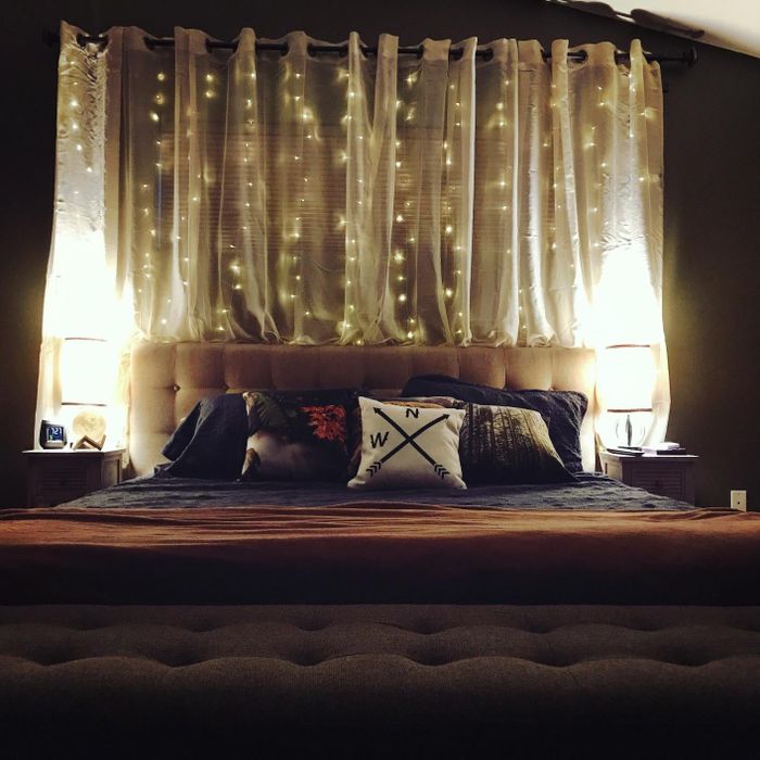 A reviewer's photo showing twinkle lights hanging behind their bed