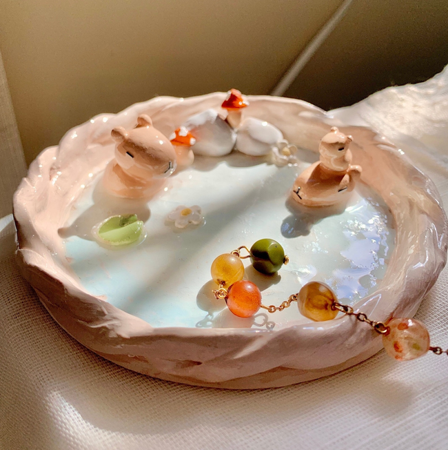 Decorative dish featuring tiny animal figurines in a whimsical water scene
