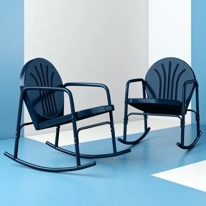 Two modern navy blue rocking chairs with curved backs and armrests, set in a minimalist space. These chairs offer both style and comfort for any setting.