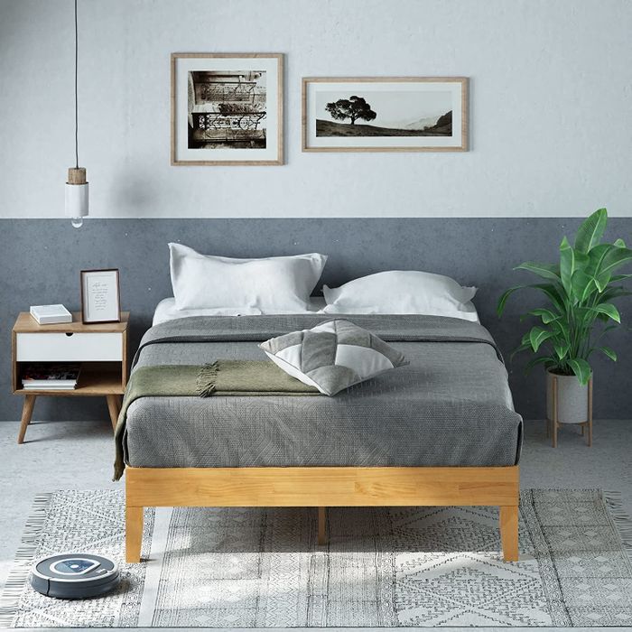 Image of a bed frame with gray linens.